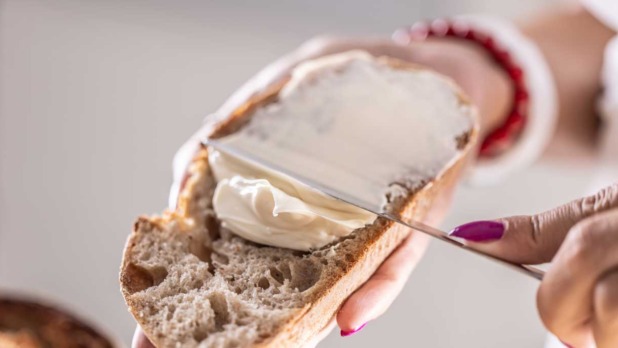 vrouw smeert margarine op brood