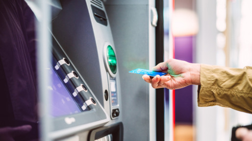 Vrouw pint geld uit betaalautomaat