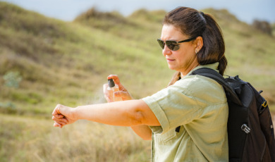 oudere vrouw spuit zich in tegen insectenbeten
