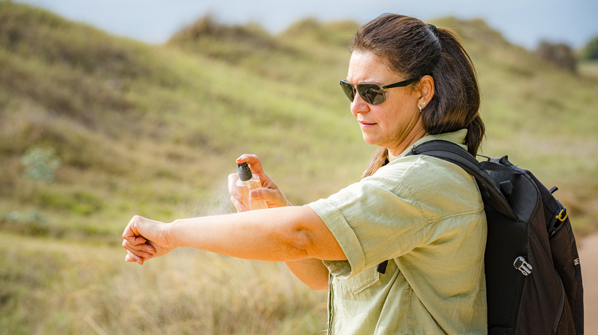 oudere vrouw spuit zich in tegen insectenbeten