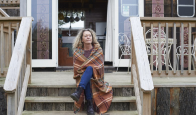 Vrouw zit peinzend op veranda