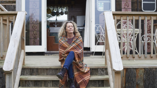 Vrouw zit peinzend op veranda