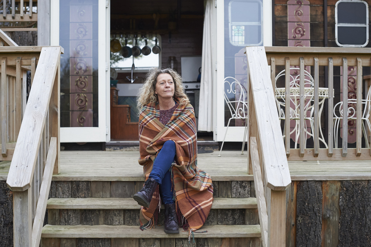 Vrouw zit peinzend op veranda