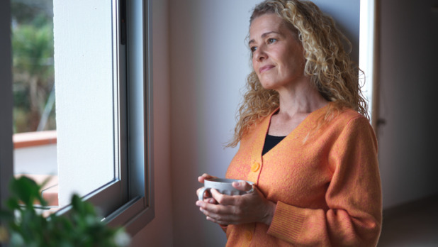 Vrouw drinkt koffie in haar slaapkamer