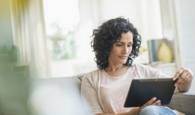 Vrouw met tablet op de bank