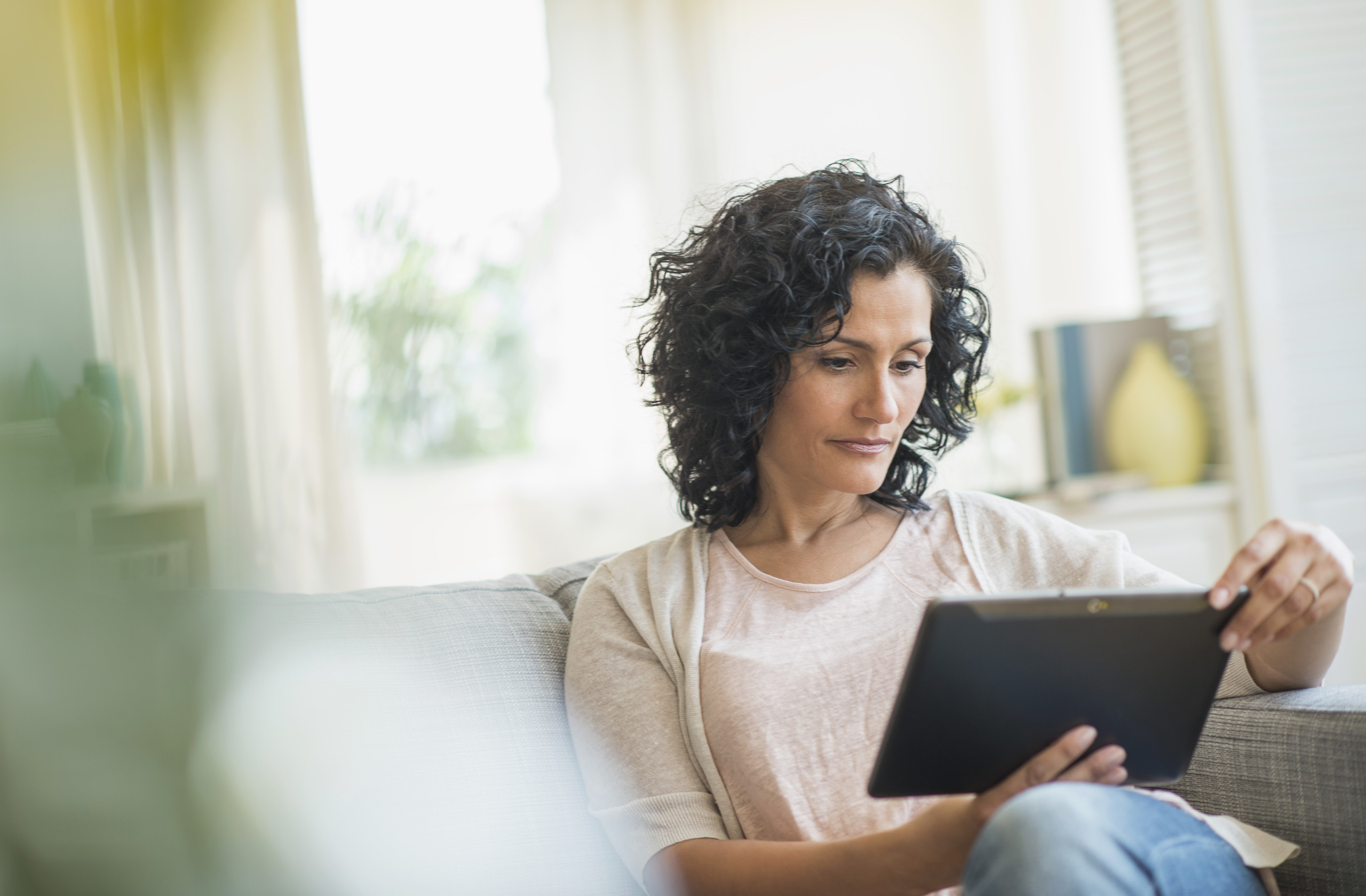 Vrouw met tablet op de bank