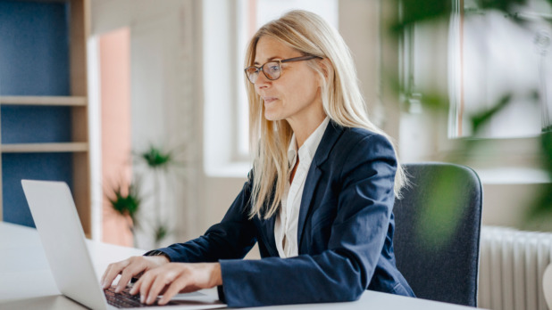 Werkende vrouw achter laptop
