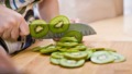 Vrouw snijdt kiwi's