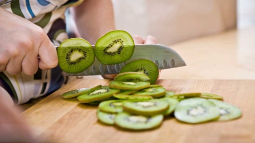 Vrouw snijdt kiwi's