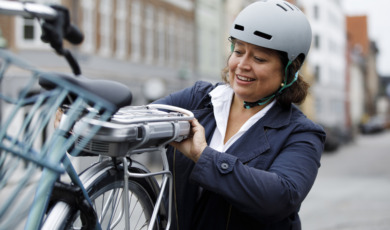Woman changing battery on electric bicycle