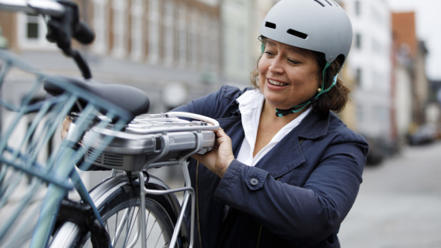 Woman changing battery on electric bicycle