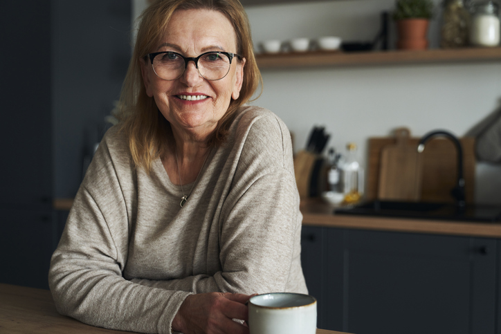 Vrouw leunt op aanrecht in de keuken