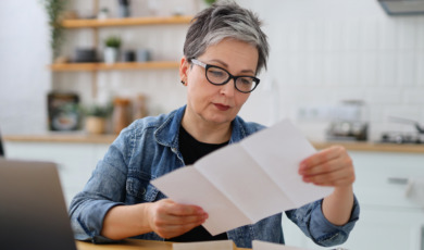 oudere vrouw bekijkt lijst op papier