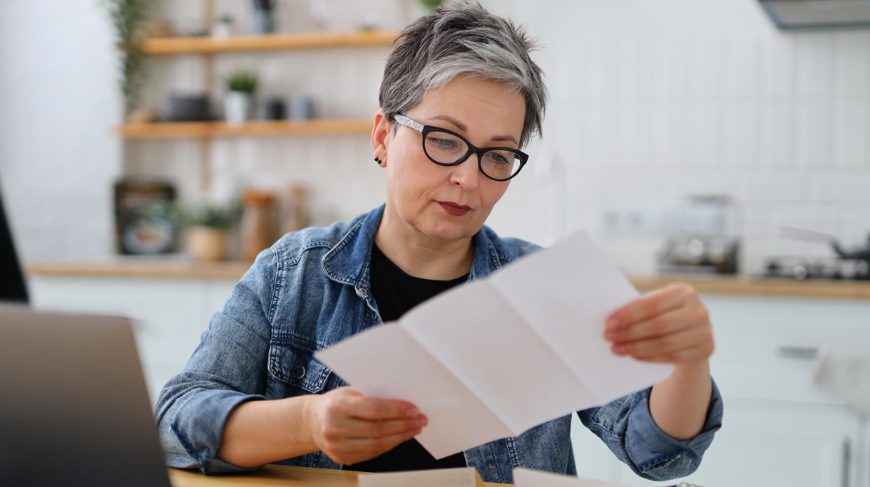 oudere vrouw bekijkt lijst op papier
