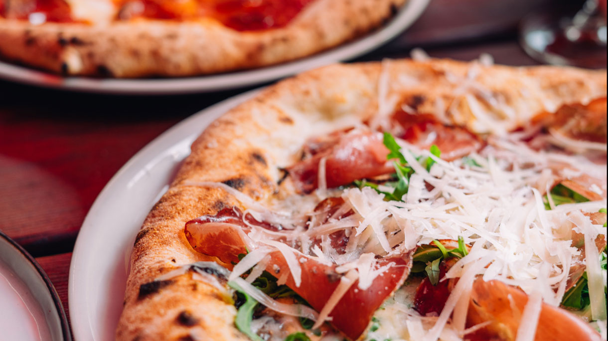 Een pizza met kaas en prosciutto