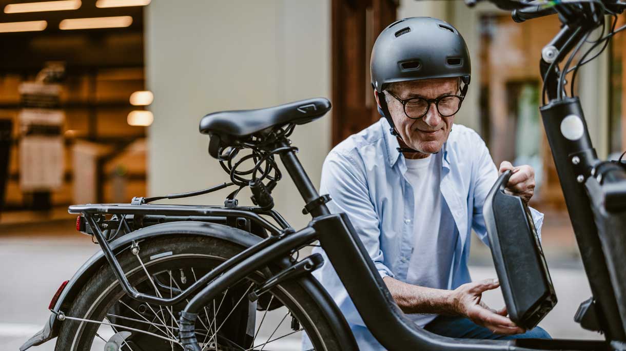 Man met fietshelm bij e-bike