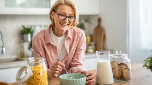 Vrolijke vrouw eet havermout in de keuken
