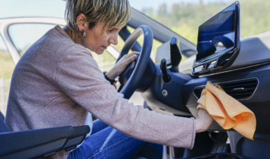 oudere vrouw maakt auto van binnen schoon