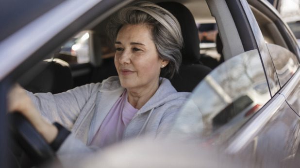 oudere vrouw met pijn in de auto