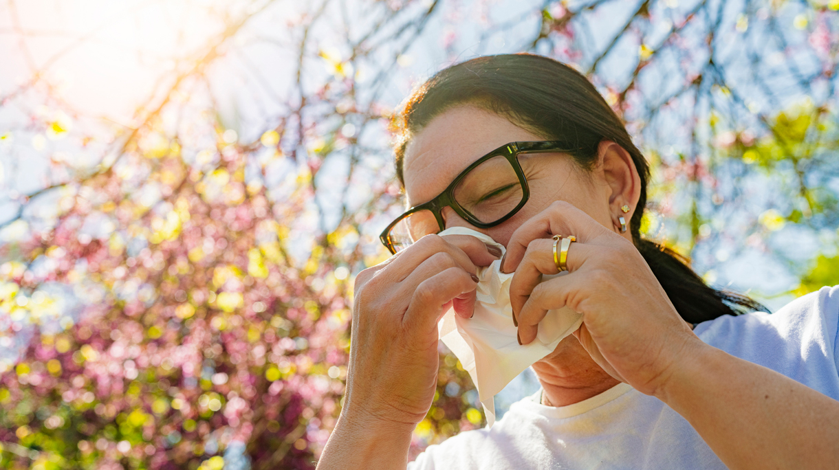 Vrouw in de lente met hooikoorts. Ze moet niezen.