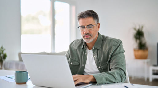 Oudere man zoekt op laptop naar informatie
