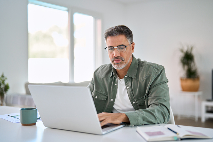 Oudere man zoekt op laptop naar informatie