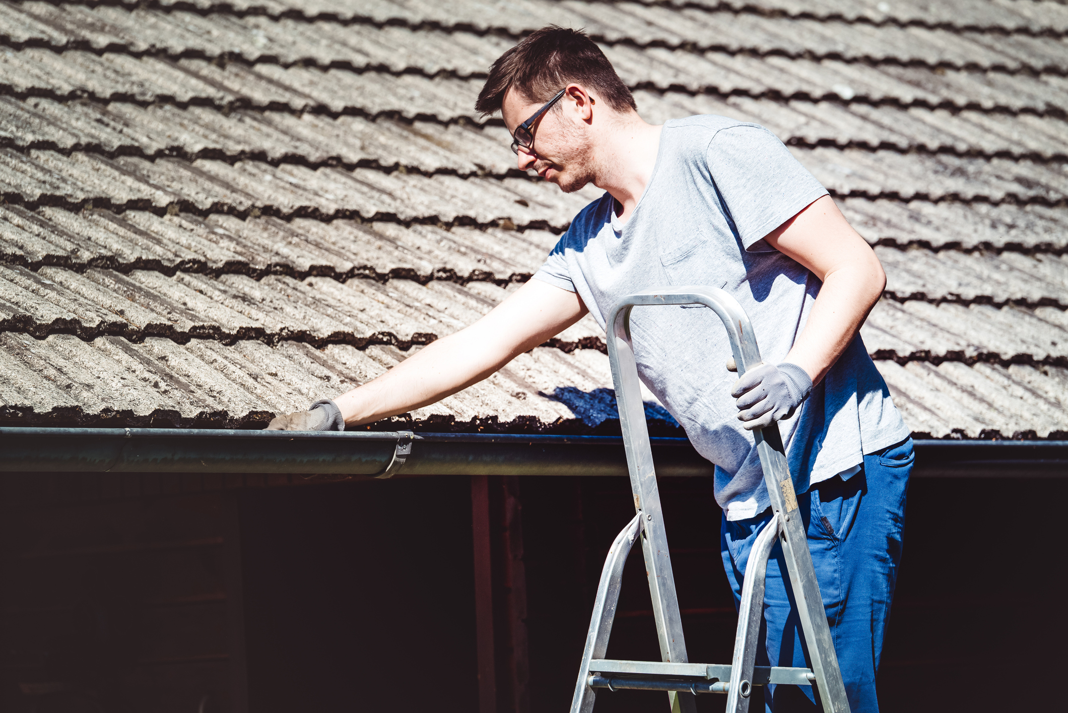 Man maakt dakgoot schoon