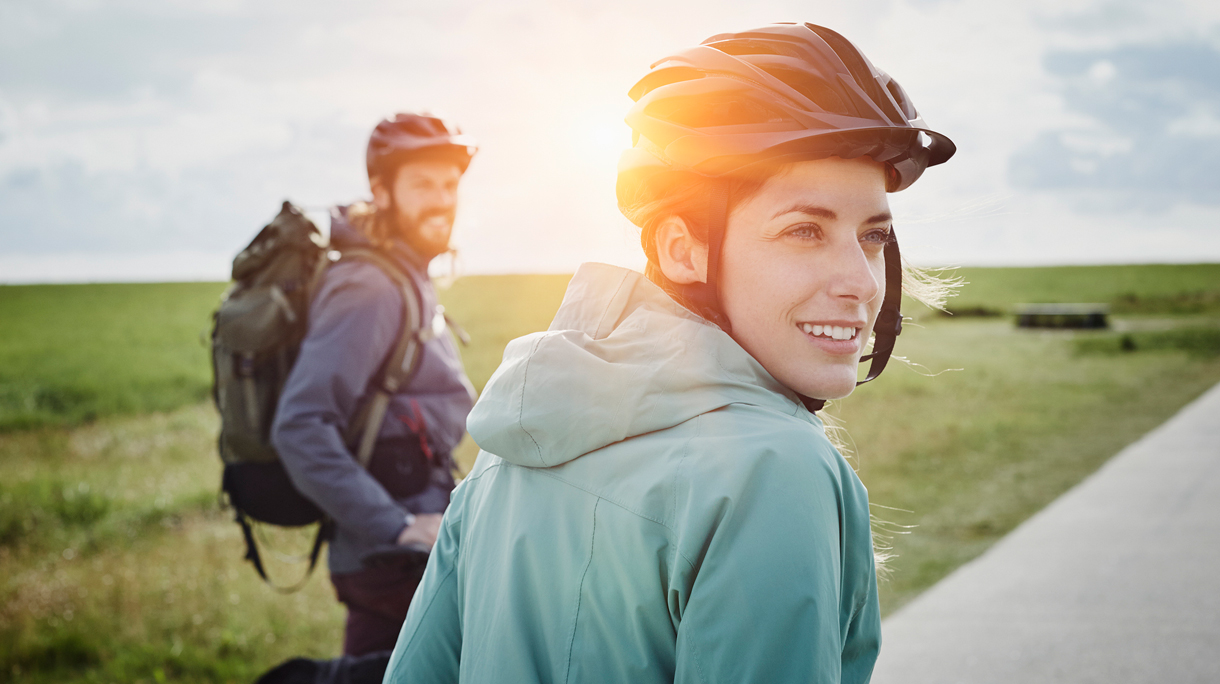 Vrouw en man op een zonnige voorjaarsdag op de fiets met fietshelm