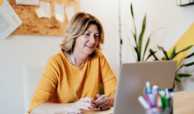 Vrouw zit achter haar laptop te lezen