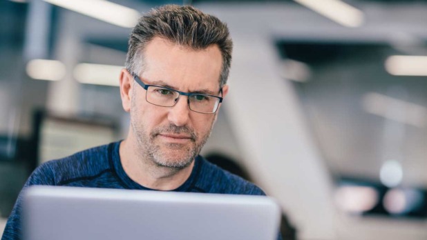 man achter laptop