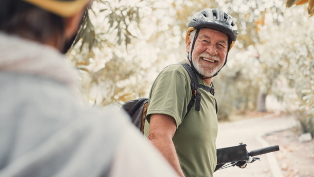 Man en vrouw op vakantie, dragen een helm op de fiets