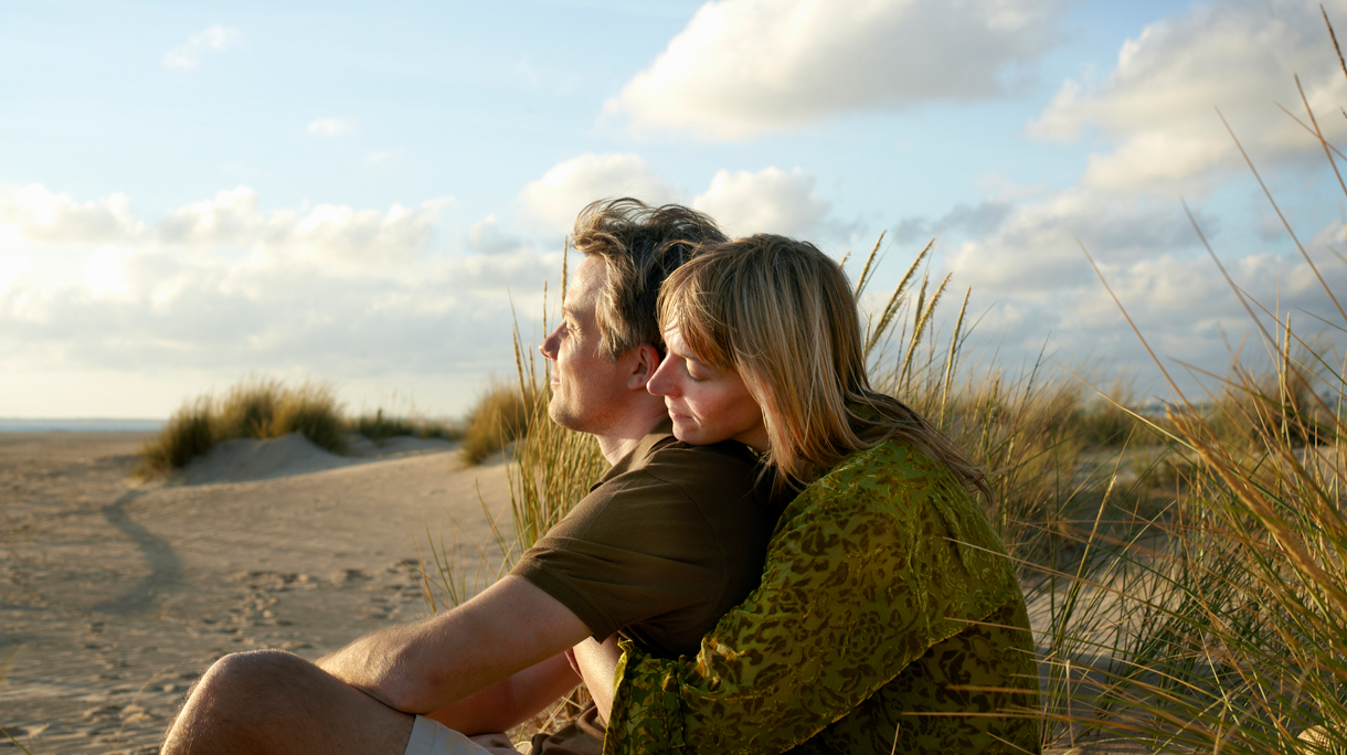 Stel op het strand kijkt naar de zee en de lucht