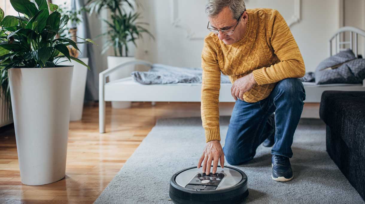man met slimme robotstofzuiger