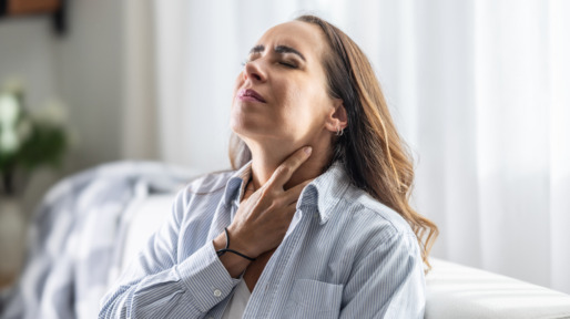 Vrouw heeft last van gallige reflux en grijpt naar haar keel