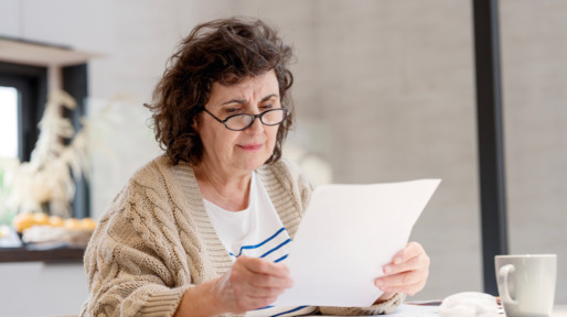 Vrouw doet de thuisadministratie en leest papieren