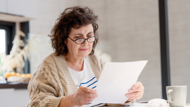 Vrouw doet de thuisadministratie en leest papieren