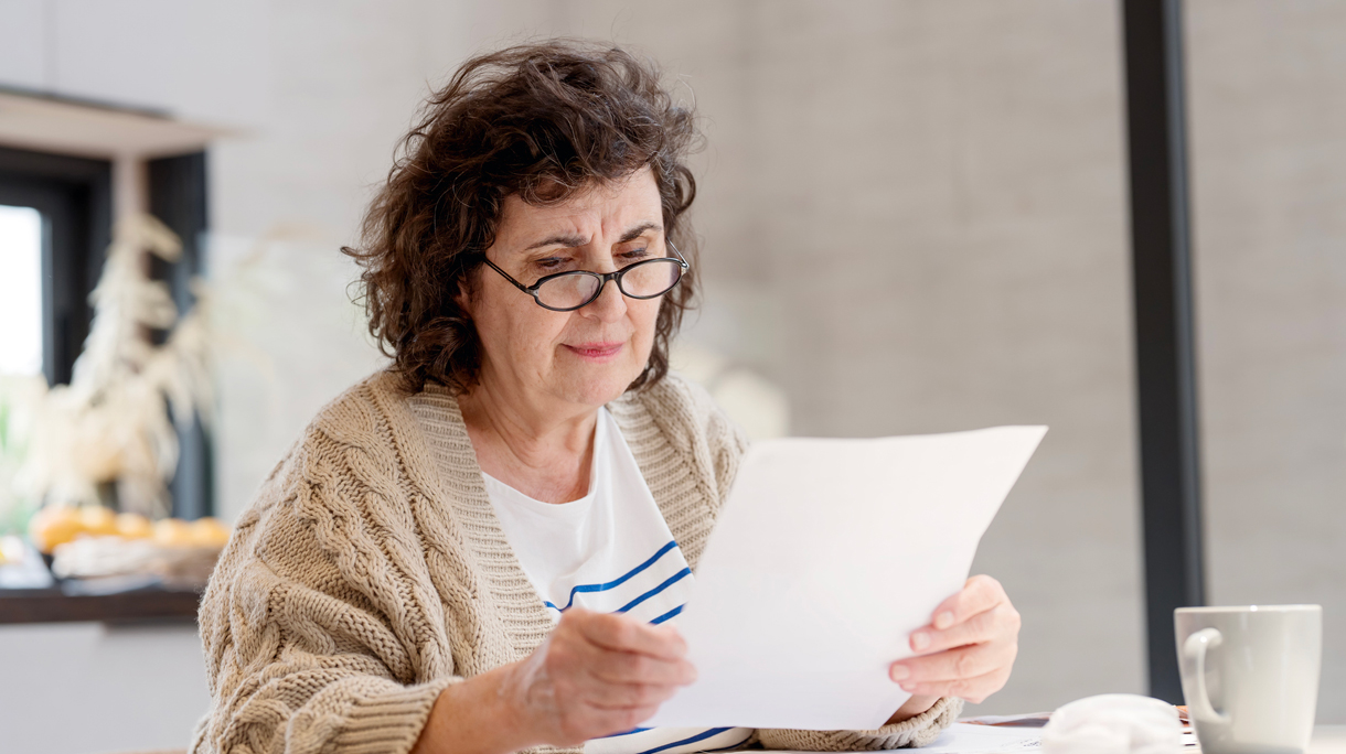 Vrouw doet de thuisadministratie en leest papieren