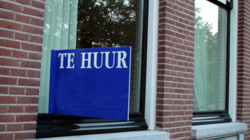 Huis met een te huur bord op het raam