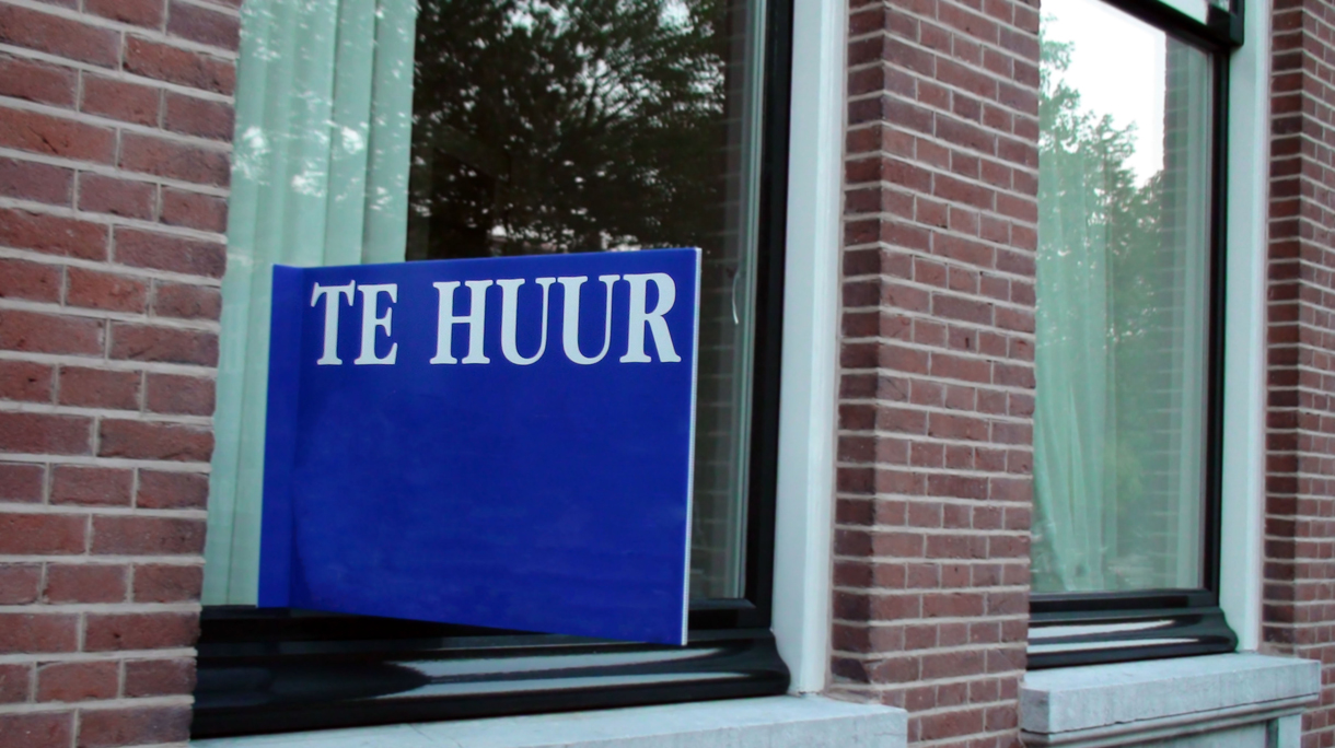 Huis met een te huur bord op het raam