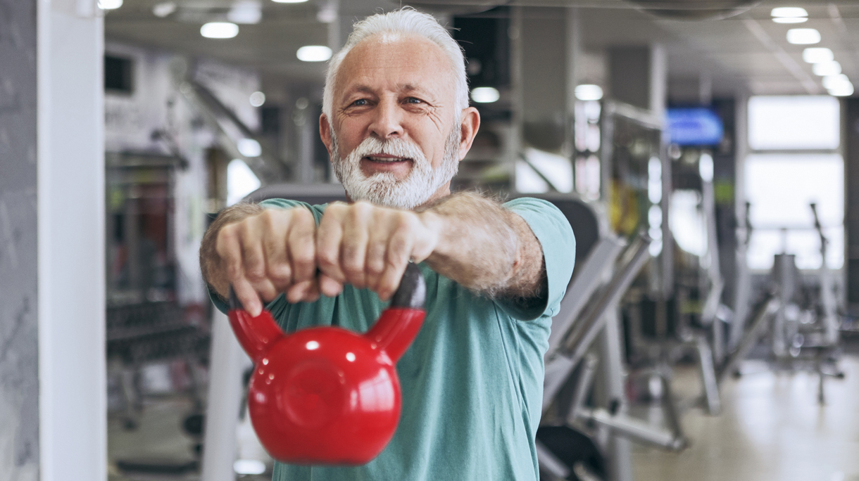 oudere man houdt kettlebell vast