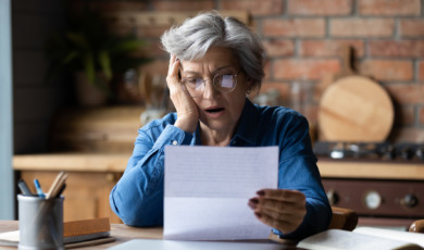 Oudere vrouw leest geschokt een brief