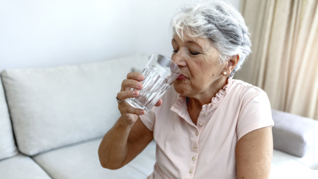 oudere vrouw drinkt water met warm weer
