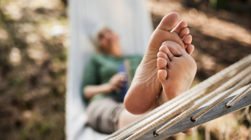 oudere vrouw in hangmat met voeten