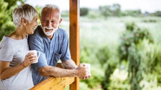 Man en vrouw drinken koffie op het terras van hun huis