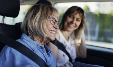 senior vrouw lacht in auto bij dochter