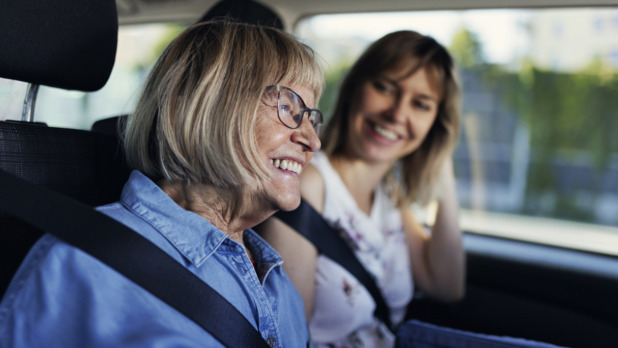senior vrouw lacht in auto bij dochter