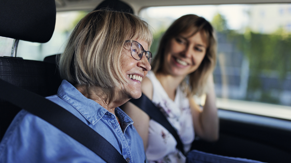 senior vrouw lacht in auto bij dochter