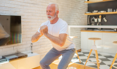 senior man doet squats thuis