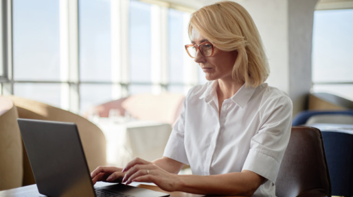 Vrouw zit achter haar laptop te werken