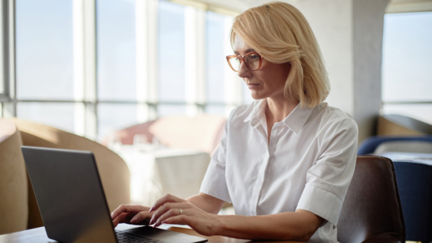 Vrouw zit achter haar laptop te werken